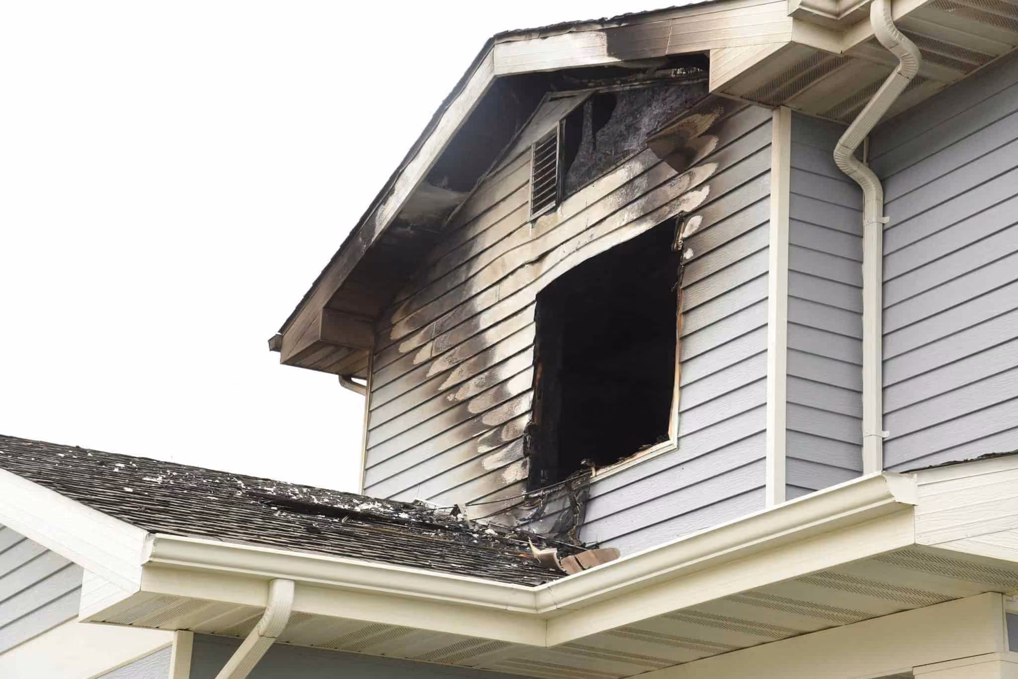 House with fire and smoke damage around an upper window